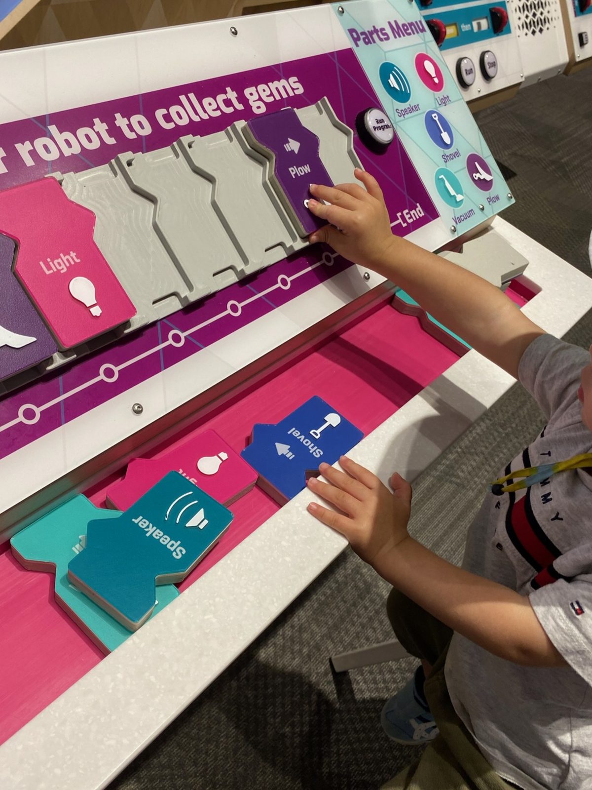 カードを並べてロボットをプログラミングする展示で遊ぶ子ども